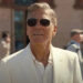 George Clooney as Jay Kelly, watches from behind shades as his daughter drives away on a bus. .