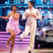 Balvinder Sopal in 1920s flapper dress with her dance  partner Julian Caillon in a white suit dancing on stage at Strictly with a vintage car behind them