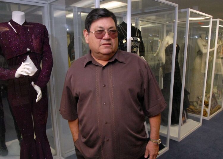 Abraham Quintanilla, father of late singer Selena, appears in front of costumes worn by Selena in Corpus Christi, Texas on June 24, 2011. (AP Photo/Paul Iverson)