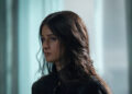 Anya Chalotra's Yennefer stands against a blurred background in The Witcher