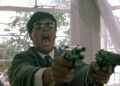 Chow Yun-fat as Ken "Gor" Lee roars while firing off two handguns in A Better Tomorrow II