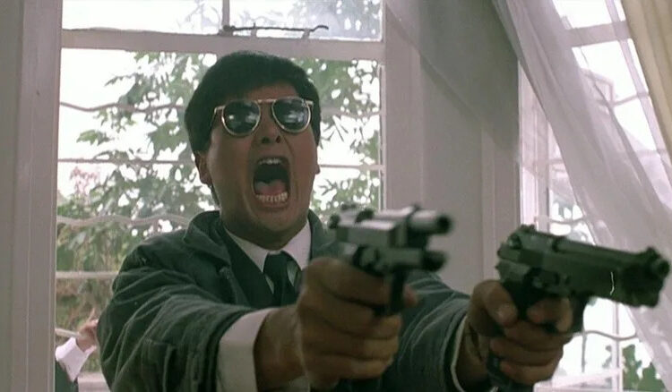 Chow Yun-fat as Ken "Gor" Lee roars while firing off two handguns in A Better Tomorrow II