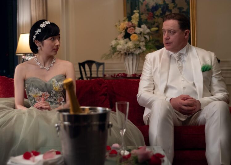 A nervous man in a white suit plays a role at a Japanese wedding.