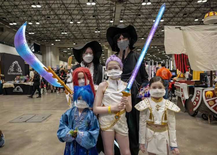 Cassandra Wheeler, left, and her husband, Josh, cosplay as characters from the movie “K-Pop Demon Hunters” during Planet Anime at the Kansas City Convention Center on Saturday, Nov. 22, 2025.