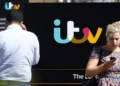 Alamy Two people walk outside the ITV studio with a big ITV logo in the background.