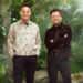 Ant and Dec stood next to each other smiling ahead in a jungle background.