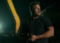 Alan Ritchson as Reacher holding a pistol