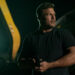 Alan Ritchson as Reacher holding a pistol