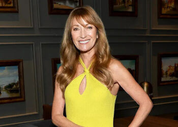 Jane Seymour smiling in a yellow halter dress