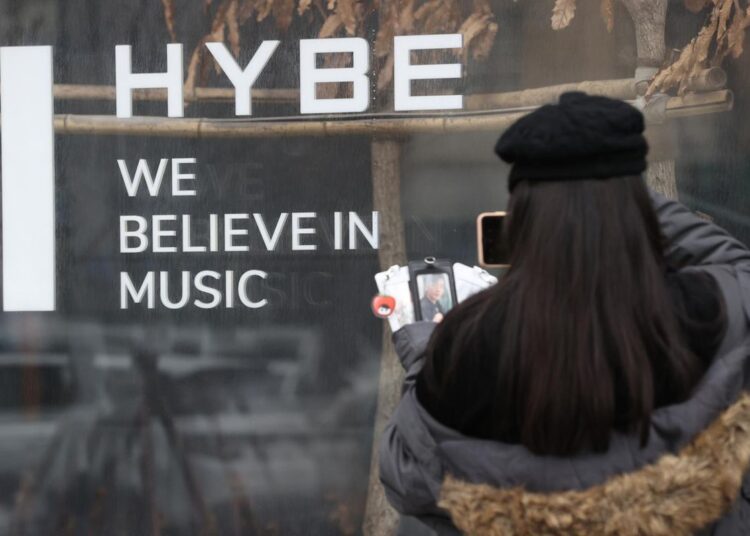 A visitor takes a photo at the main building of HYBE, the Korean entertainment giant behind BTS, in Seoul, Feb. 10. Yonhap