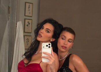 two individuals posing together in stylish evening dresses