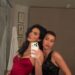 two individuals posing together in stylish evening dresses
