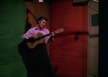Elvis playing a guitar backstage in Elvis