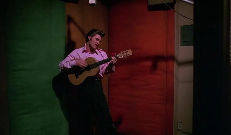 Elvis playing a guitar backstage in Elvis