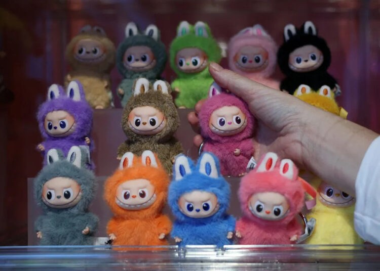 A person holds a PopMart Labubu The Monsters Big into Energy Series Vinyl Plush dolls during a press preview at an AliExpress pop-up store on Nov. 11, 2025.