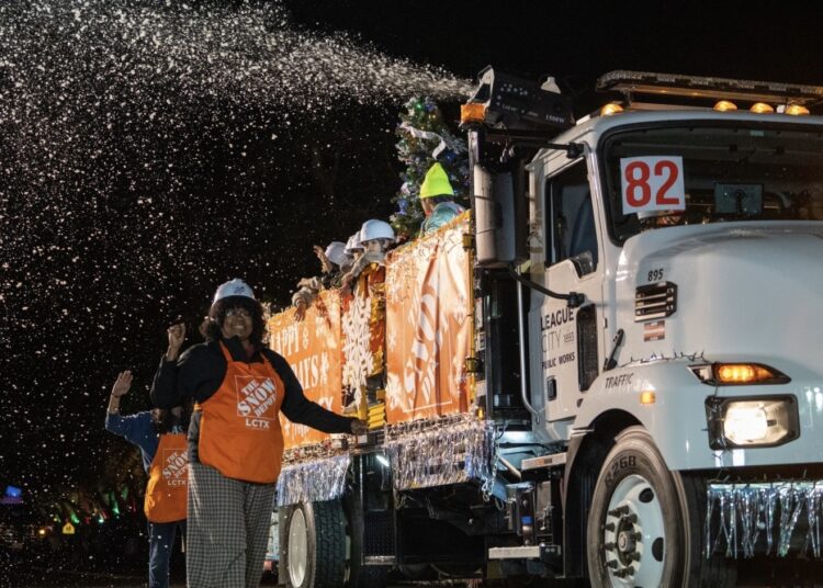 a tall white truck sprays fake snow into the air