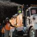 a tall white truck sprays fake snow into the air
