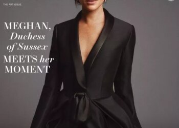 Meghan on the cover in a black suit