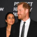 Meghan Markle admiring Prince Harry as they both wearing matching black outfits.