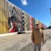 Photo of Mauricio Martinez with his mural in Oshkosh.