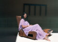 Manizeh - Photo by Florian Schneider. Manizeh resting on a lounge chair, wearing a violet dress.