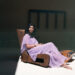 Manizeh - Photo by Florian Schneider. Manizeh resting on a lounge chair, wearing a violet dress.