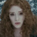 Bryce as Victoria stares intently in a wintery forest setting, appearing concerned or determined