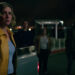 Rhea Seehorn as Carol Sturka looking worriedly at several people surrounding her in Pluribus