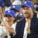 Prince Harry and his wife, Meghan, in LA Dodgers caps at the game. Pic: John Angelillo/UPI/Shutterstock