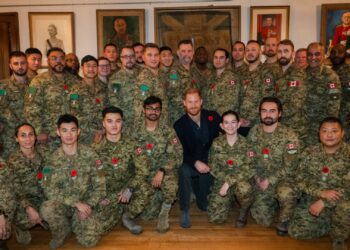 Prince Harry crouching with a group of soldiers