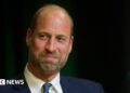 Prince William is photographed at the Earthshot Prize awards in Rio de Janeiro on 5 November. He is wearing a dark suit, white shirt and navy and blue spotty tie.