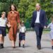 Prince William and his wife Catherine pictured with their children, linking hands, in school uniforms