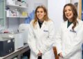 Princess Beatrice and a woman wearing white lab coats and smiling