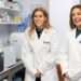 Princess Beatrice and a woman wearing white lab coats and smiling
