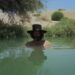 Alejandro Jodorowsky as El Topo stands with his head emerging from a pool of water in El Topo