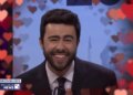 Ramy Youssef as Zohran Mamdani laughing during a debate in a Saturday Night Live sketch.