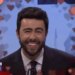 Ramy Youssef as Zohran Mamdani laughing during a debate in a Saturday Night Live sketch.