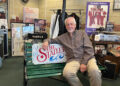 Don Reid, a founding member of the Statler Brothers, sits on a bench inside a display of memorabilia from the country music group.