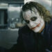 Heath Ledger's Joker holds out his hands in a kitchen in The Dark Knight Rises