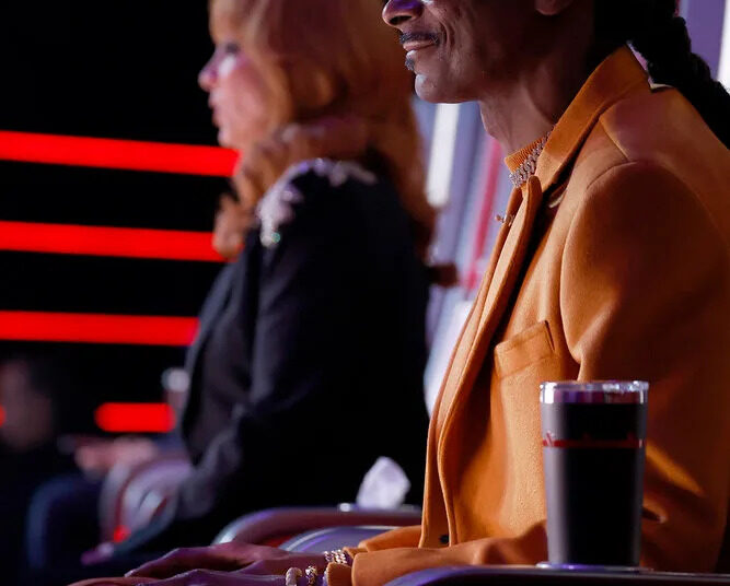 Snoop Dogg and Reba sitting in their red chairs on The Voice