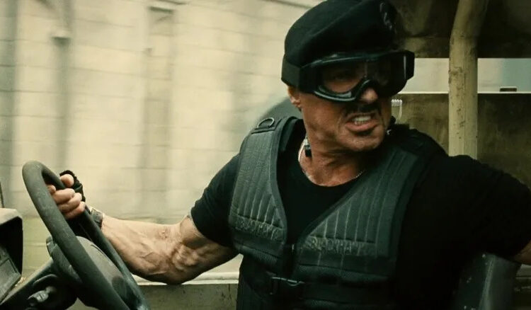 Barney Ross in a vehicle and goggles in The Expendables 2