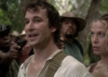Noah Wyle as Flynn Carsen stands beside Sonya Walger as Nicole Noone while surrounded by guns in The Librarian: Quest for the Spear