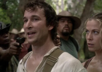 Noah Wyle as Flynn Carsen stands beside Sonya Walger as Nicole Noone while surrounded by guns in The Librarian: Quest for the Spear