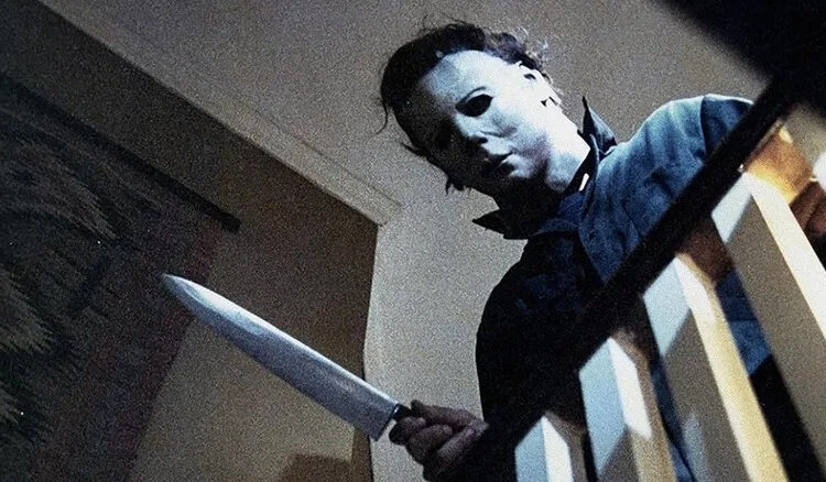 Michael Myers leaning over the stair railing in Halloween (1978)