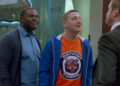 Sam Duvet, in blue, and Tim Cramblin, in an orange Detroit Tigers tshirt, glare and taunt a rival businessman in a suit in "Detroiters"