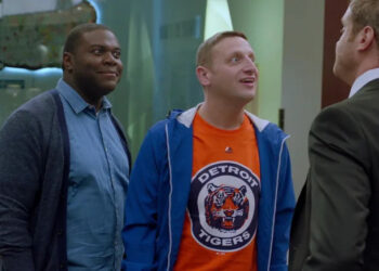 Sam Duvet, in blue, and Tim Cramblin, in an orange Detroit Tigers tshirt, glare and taunt a rival businessman in a suit in "Detroiters"