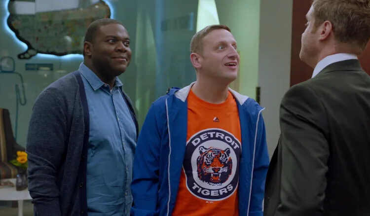 Sam Duvet, in blue, and Tim Cramblin, in an orange Detroit Tigers tshirt, glare and taunt a rival businessman in a suit in "Detroiters"