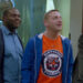 Sam Duvet, in blue, and Tim Cramblin, in an orange Detroit Tigers tshirt, glare and taunt a rival businessman in a suit in "Detroiters"