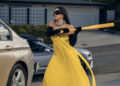 Kim Kardashian as Allura Grant hitting a car with a baseball bat while wearing a formal gown on All's Fair