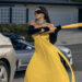 Kim Kardashian as Allura Grant hitting a car with a baseball bat while wearing a formal gown on All's Fair